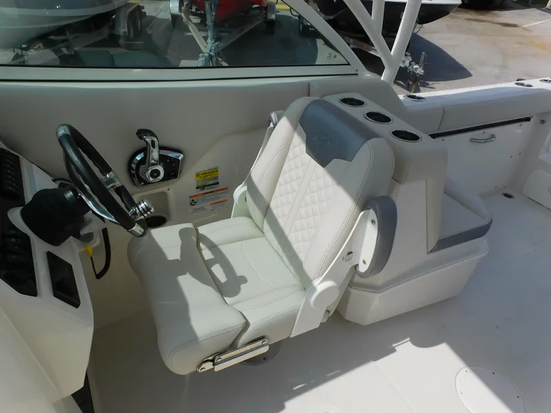 Slide: The Image of 2025 Sailfish 245 DC boat interior with white captain's chair and steering wheel. - 15