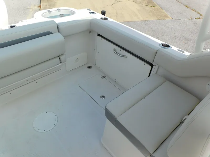 Slide: The Image of 2025 Sailfish 245 DC boat interior with white seating and storage compartments. - 17