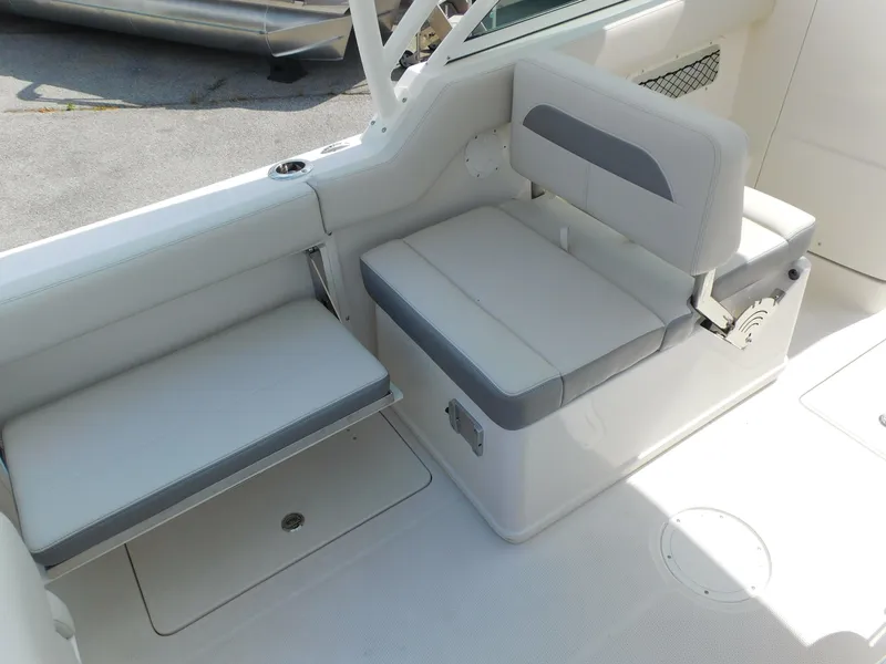 Slide: The Image of 2025 Sailfish 245 DC boat interior seating with white and gray cushions. - 21