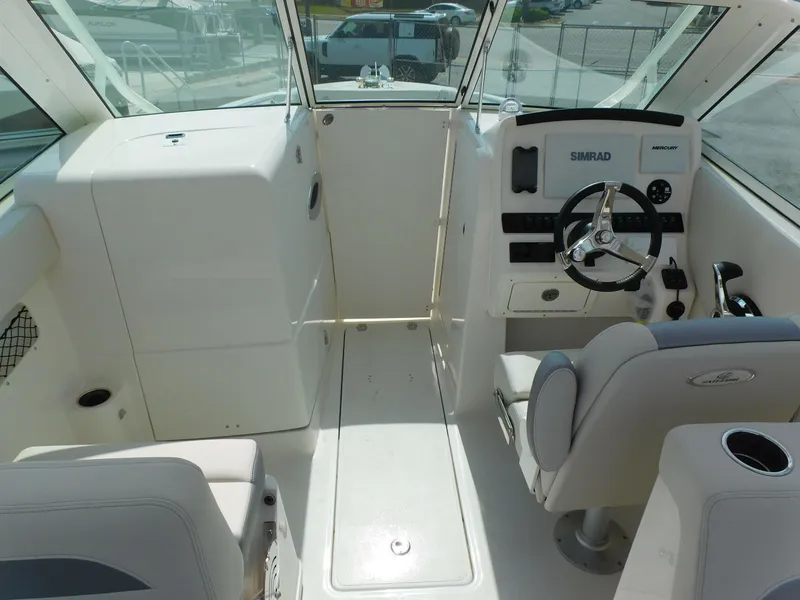 Slide: The Image of 2025 Sailfish 245 DC boat interior with steering wheel and seating. - 24
