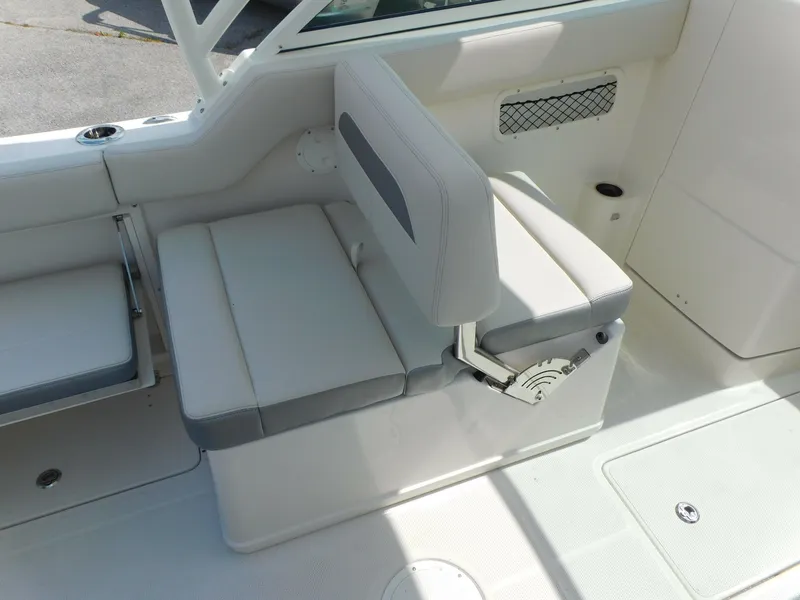 Slide: The Image of 2025 Sailfish 245 DC boat interior seating with white and gray cushions. - 25