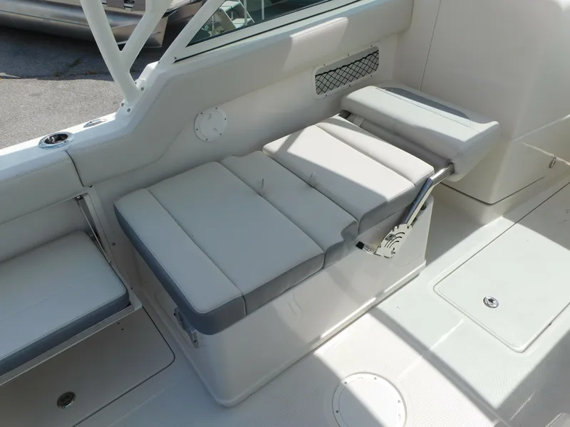 Slide: The Image of 2025 Sailfish 245 DC boat interior seating with white and gray cushions. - 27