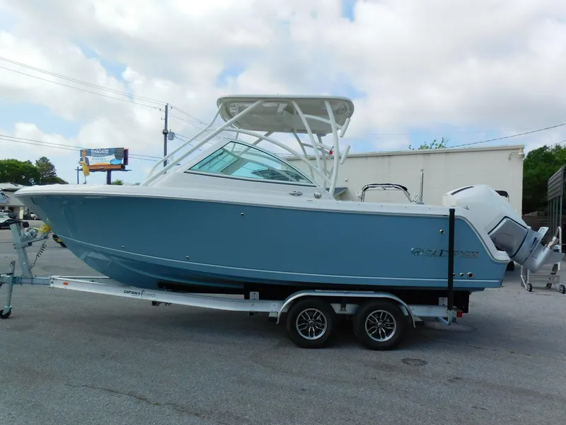 Slide: The Image of 2025 Sailfish 245 DC boat on trailer, light blue hull, dual engines, parked outdoors. - 3