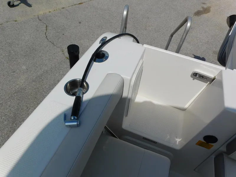 Slide: The Image of 2025 Sailfish 245 DC boat interior with seating and a hose attachment. - 32