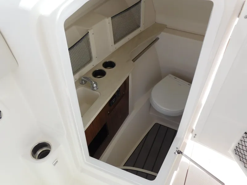 Slide: The Image of 2025 Sailfish 245 DC boat interior with sink, toilet, and storage compartments. - 7