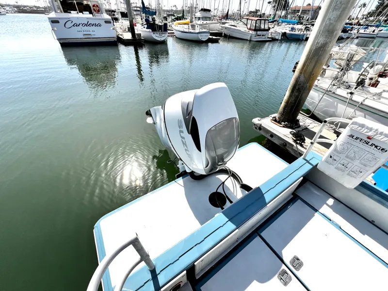 Slide: The Image of Boat docked with Suzuki outboard motor, surrounded by marina and sailboats. - 9