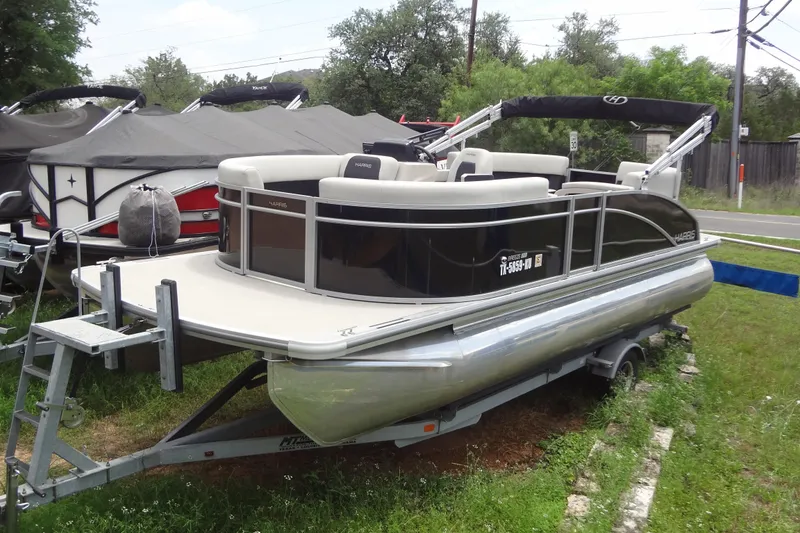 The Image of 2024 Harris FloteBote 210 Breeze pontoon boat on trailer, parked outdoors. - 0