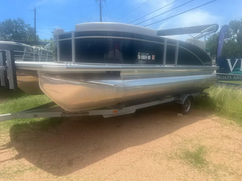 The Image of 2024 Harris FloteBote 210 Breeze pontoon boat on a trailer, parked outdoors. - 1