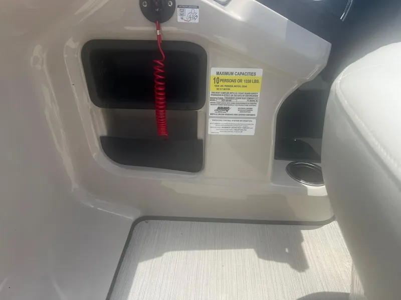 Slide: The Image of 2024 Harris FloteBote 210 Breeze interior with safety label and storage compartment. - 16