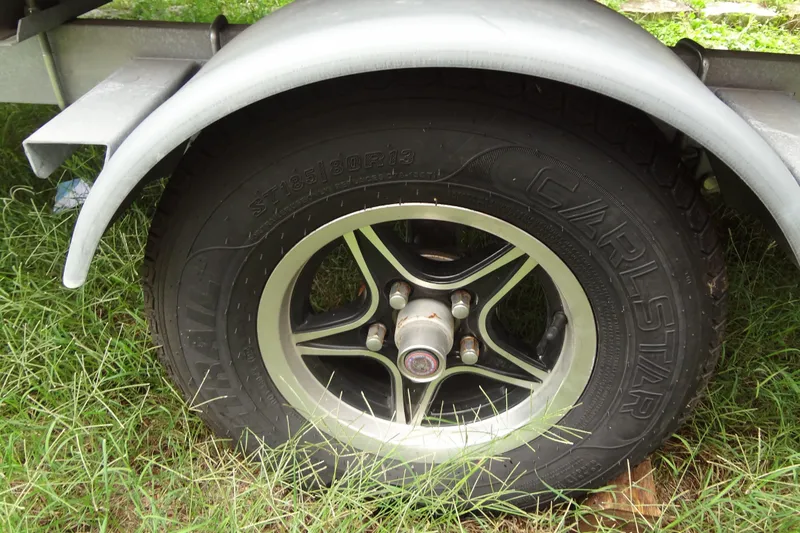 Slide: The Image of Trailer wheel of a 2024 Harris FloteBote 210 Breeze on grassy ground. - 31