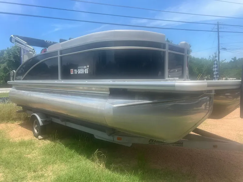Slide: The Image of 2024 Harris FloteBote 210 Breeze pontoon boat on trailer, parked outdoors. - 4