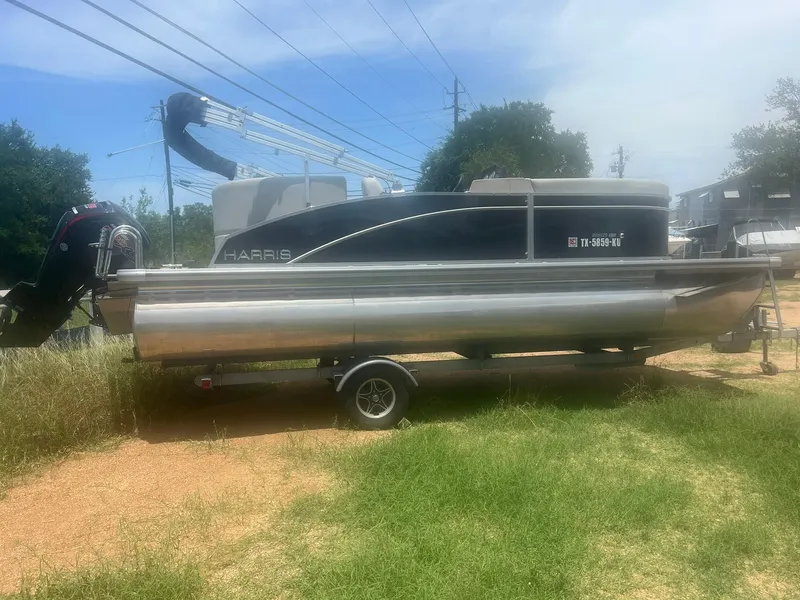 Slide: The Image of 2024 Harris FloteBote 210 Breeze pontoon boat on trailer, parked on grass. - 5