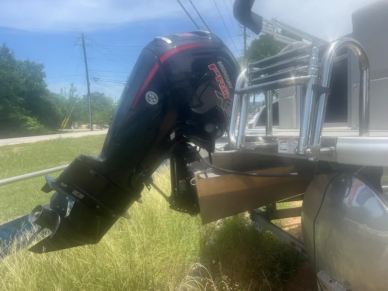 Slide: The Image of 2024 Harris FloteBote 210 Breeze pontoon boat with outboard motor in grassy area. - 6