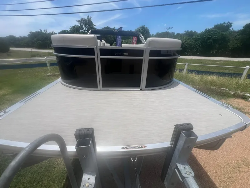 Slide: The Image of 2024 Harris FloteBote 210 Breeze pontoon boat on trailer, outdoor setting. - 8