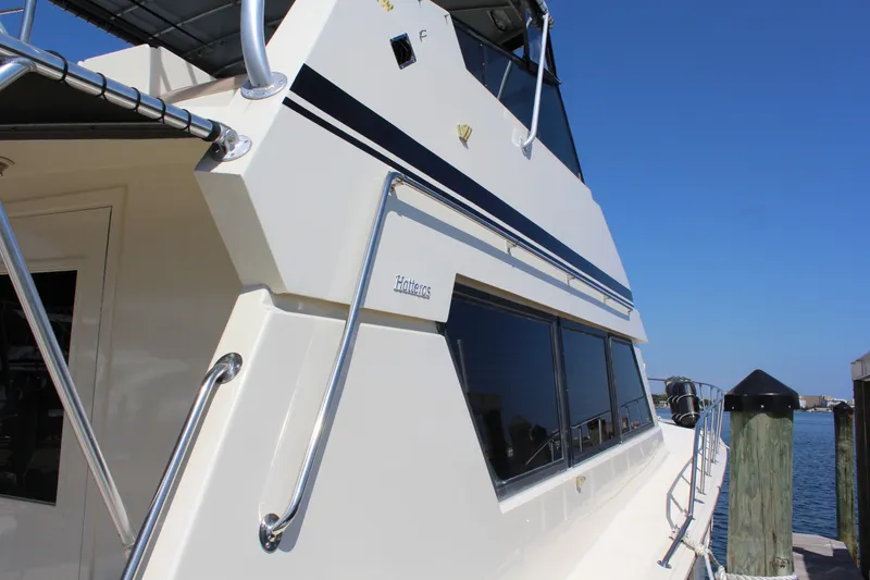 Slide: The Image of 1987 Hatteras 65 Convertible yacht docked, showcasing sleek design and polished exterior. - 18