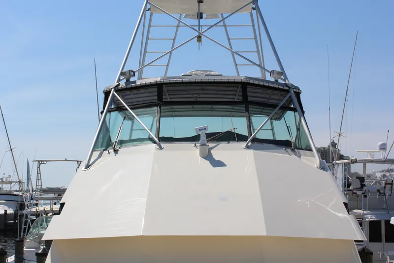 Slide: The Image of 1987 Hatteras 65 Convertible yacht docked at marina, front view. - 22