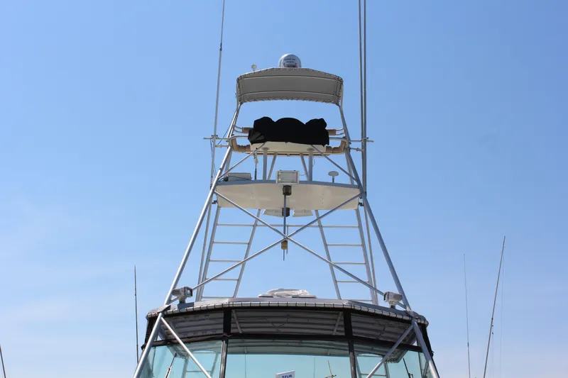 Slide: The Image of 1987 Hatteras 65 Convertible yacht tower against clear blue sky. - 23