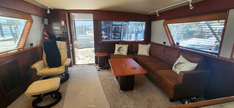 Slide: The Image of Interior of 1987 Hatteras 65 Convertible yacht with brown seating and wooden accents. - 26