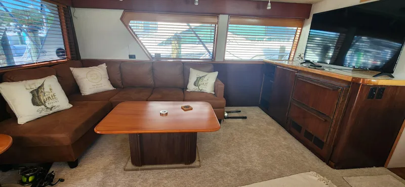 Slide: The Image of Interior of 1987 Hatteras 65 Convertible yacht with brown leather seating and wooden accents. - 28