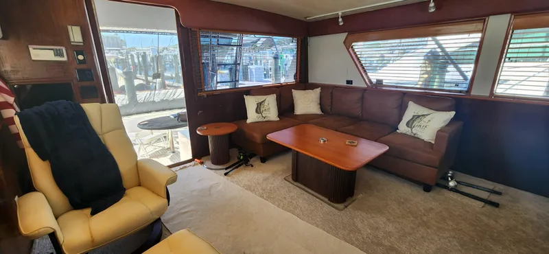 Slide: The Image of Interior of 1987 Hatteras 65 Convertible yacht with leather seating and wooden table. - 29