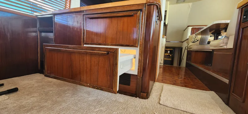 Slide: The Image of 1987 Hatteras 65 Convertible yacht interior with wooden cabinetry and open drawer. - 30