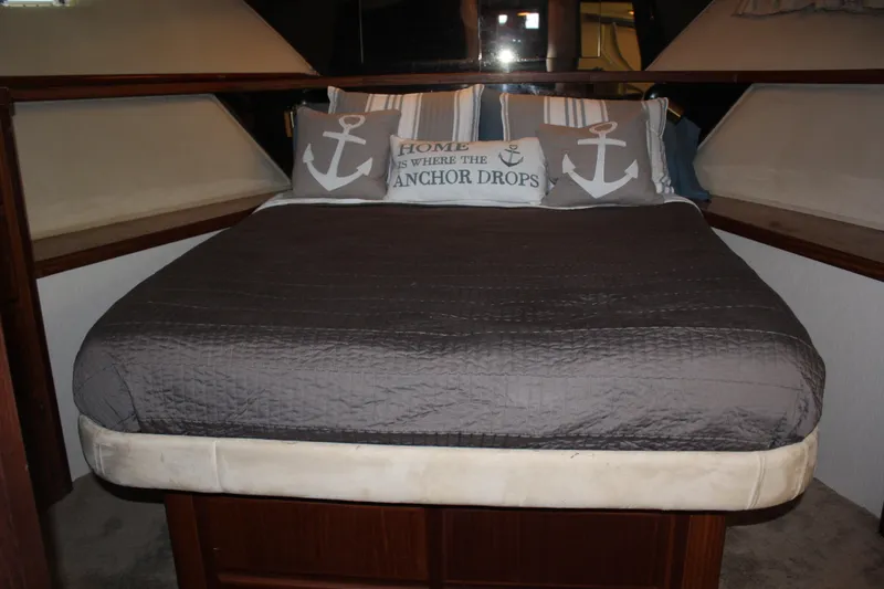 Slide: The Image of Cozy bedroom in 1987 Hatteras 65 Convertible yacht with nautical-themed pillows. - 32