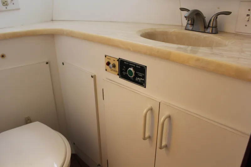 Slide: The Image of 1987 Hatteras 65 Convertible yacht bathroom with sink, faucet, and toilet. - 46