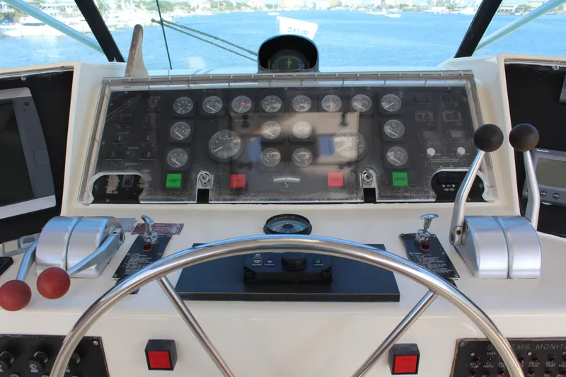 Slide: The Image of Control panel of 1987 Hatteras 65 Convertible yacht with steering wheel and gauges. - 48
