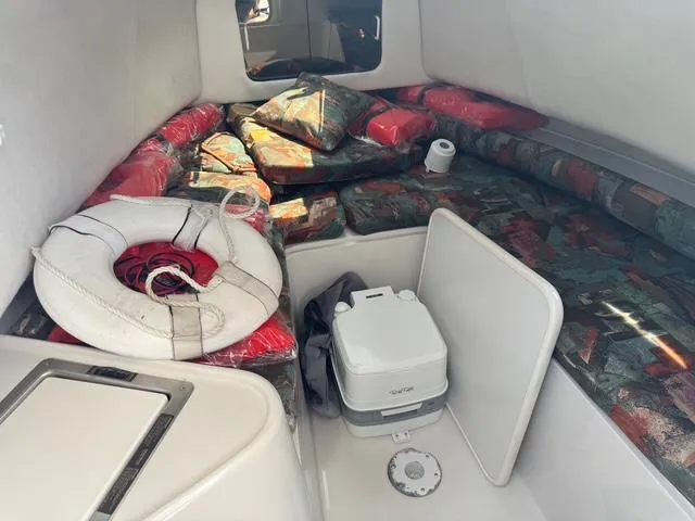Slide: The Image of Interior of 1995 Pro-Line 231 WA boat with cushions, life preserver, and portable toilet. - 14