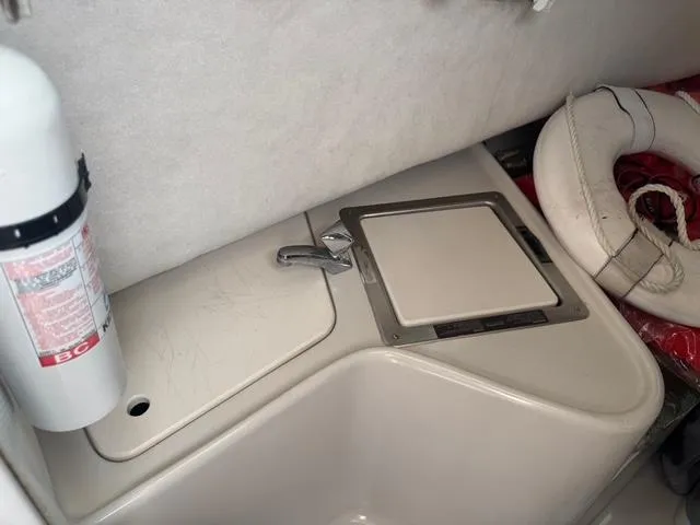 Slide: The Image of 1995 Pro-Line 231 WA boat interior with sink, fire extinguisher, and life preserver. - 15