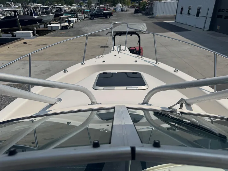 Slide: The Image of 1995 Pro-Line 231 WA boat deck view at marina, showcasing bow and railing. - 4