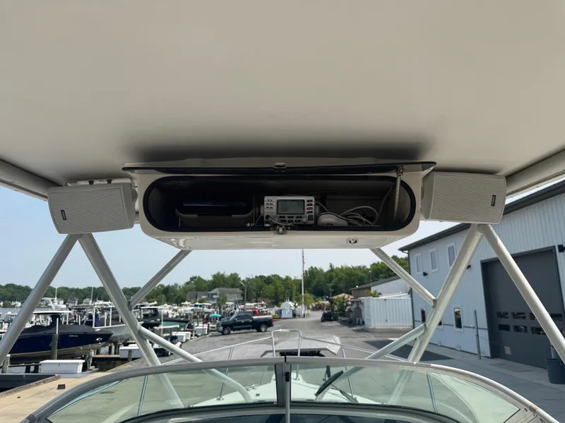 Slide: The Image of 1995 Pro-Line 231 WA boat with overhead electronics and speakers at a marina. - 7