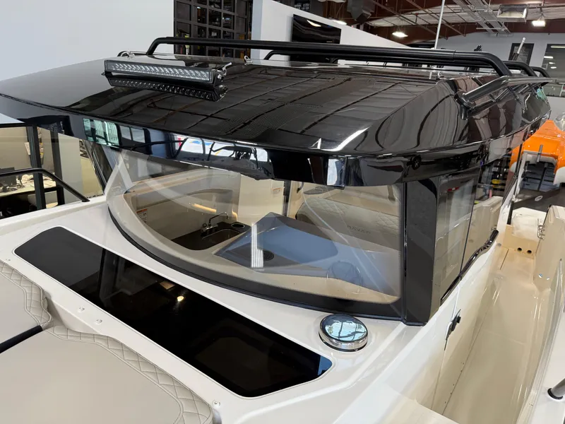 Slide: The Image of Navan C30 2025 boat with sleek black roof and modern design in showroom. - 16