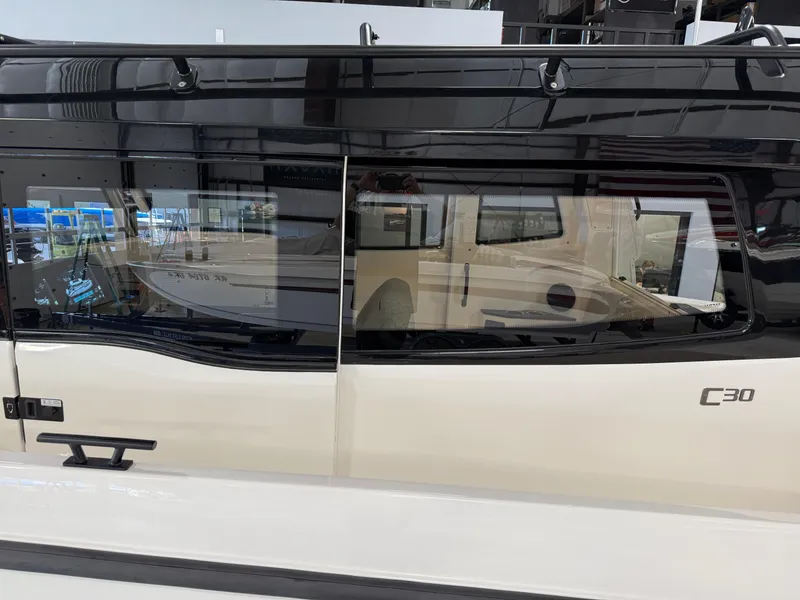 Slide: The Image of 2025 Navan C30 vehicle side view with sleek black and beige design. - 18
