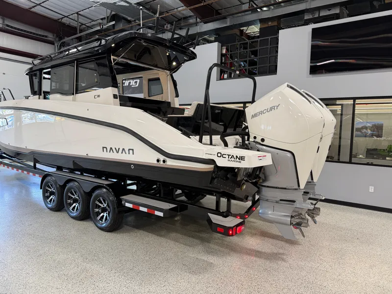 Slide: The Image of 2025 Navan C30 boat with Mercury engine on a trailer in a showroom. - 2