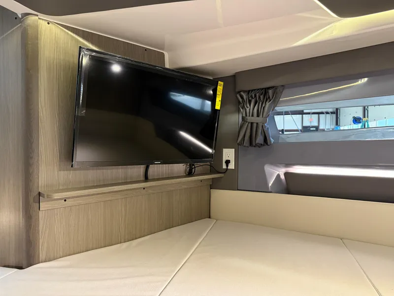 Slide: The Image of Interior of 2025 Navan C30 RV with mounted TV and window curtain. - 46