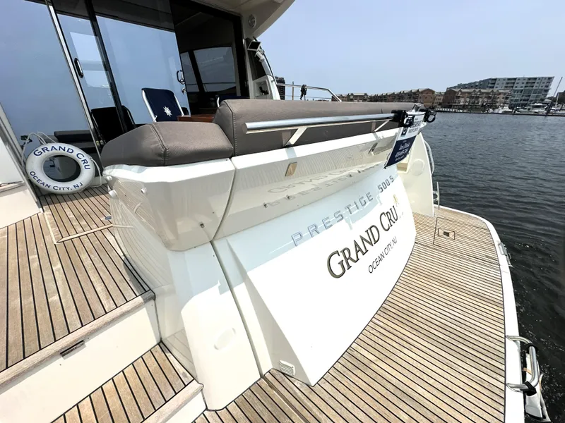 Slide: The Image of Luxury yacht Prestige 500 S, 2017 model, docked with wooden deck and "Grand Cru" signage. - 4