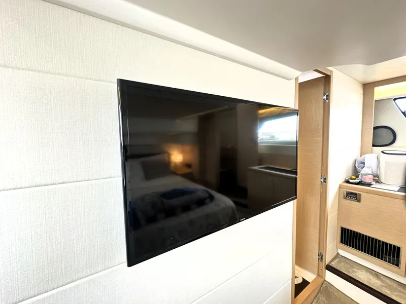 Slide: The Image of Flat-screen TV in a 2017 Prestige 500 S yacht interior, near a cozy bedroom and bathroom. - 43