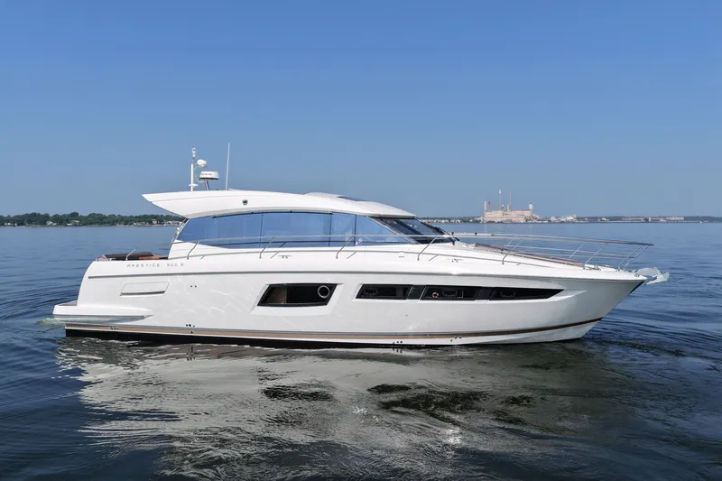 Slide: The Image of Luxury 2017 Prestige 500S yacht cruising on calm waters under clear blue sky. - 5