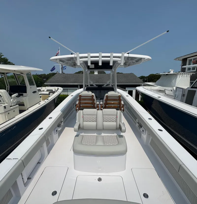 Slide: The Image of 2026 Jupiter 32 boat with dual seats and sleek design, docked under clear blue sky. - 10