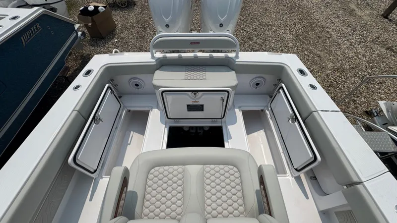 Slide: The Image of 2026 Jupiter 32 boat interior with open storage compartments and cushioned seating. - 16