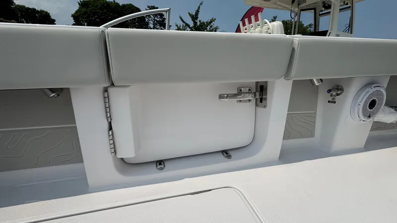 Slide: The Image of Interior view of a 2026 Jupiter 32 boat, featuring a storage compartment and speaker. - 19
