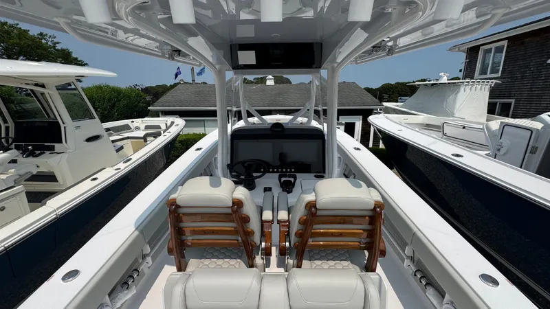 Slide: The Image of 2026 Jupiter 32 boat interior with dual seats and modern dashboard, docked alongside other boats. - 20