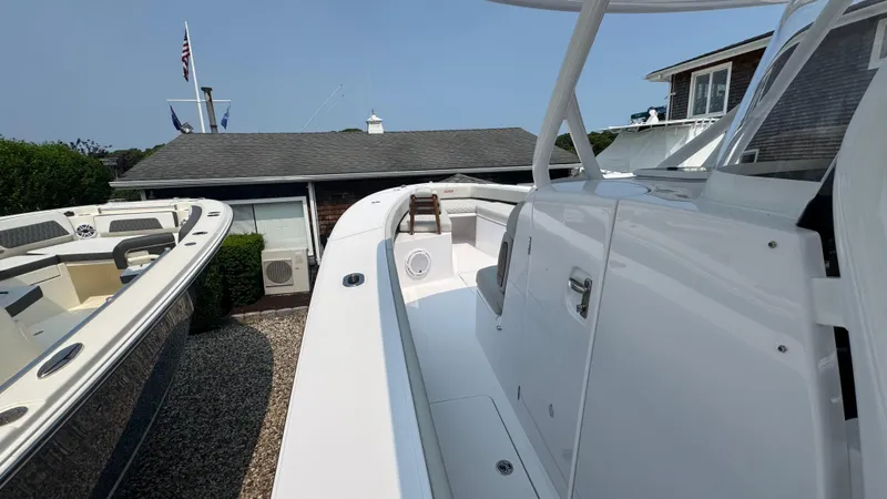 Slide: The Image of 2026 Jupiter 32 boat docked near a house, showcasing sleek design and modern features. - 26
