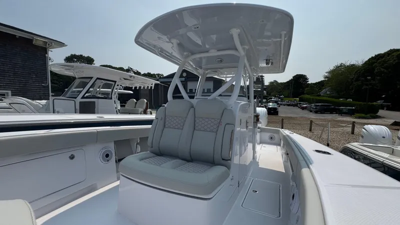 Slide: The Image of 2026 Jupiter 32 boat with dual seating and T-top in a marina setting. - 32