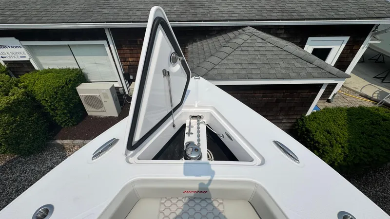Slide: The Image of Bow of 2026 Jupiter 32 boat with open hatch, docked near a building. - 41