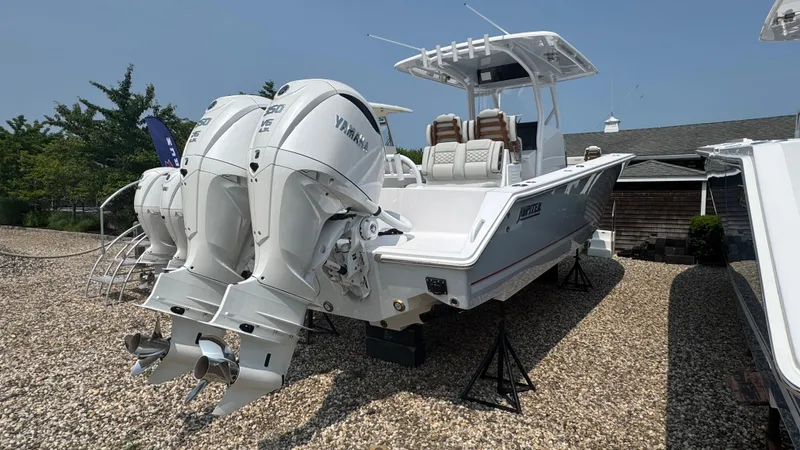 Slide: The Image of 2026 Jupiter 32 boat with dual Yamaha engines on display outdoors. - 7