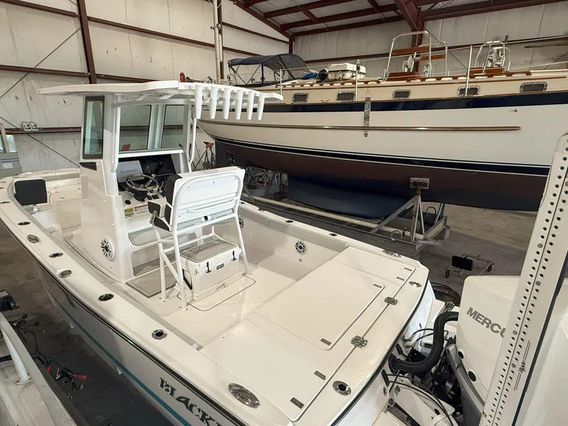 Slide: The Image of 2026 Blackfin 242HB boat in a storage facility, featuring a sleek design and Mercury engine. - 3