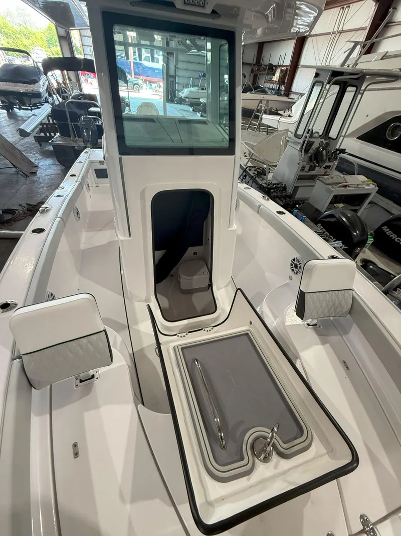Slide: The Image of 2026 Blackfin 242HB boat interior with open storage compartment in a showroom. - 30