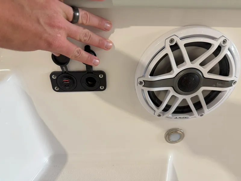 Slide: The Image of Hand near speaker and charging ports on 2026 Blackfin 242HB boat interior. - 32